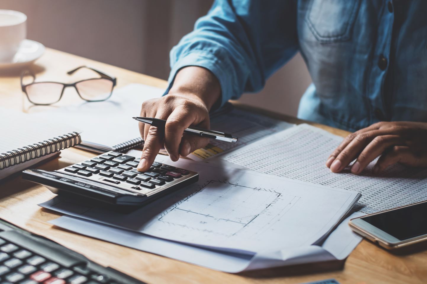 Imagen de persona con calculadora y documentos Imagen de persona con calculadora y documentos